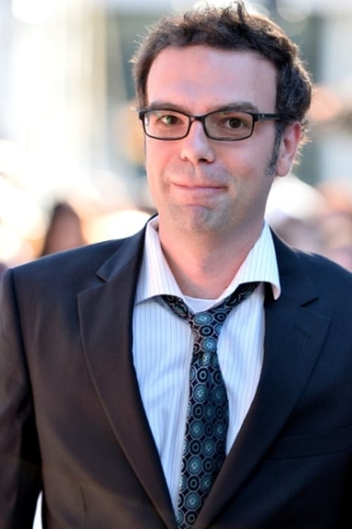 Photo of Matt Watts wearing glasses and a suit with his tie askew